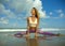 Young happy and attractive girl doing flexibility exercise with legs split  on sand in wellness harmony health care and fitness