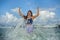 Young happy and attractive red hair woman playing excited spreading arms feeling free and relaxed getting wet by sea waves