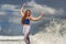 Young happy and attractive red hair woman playing excited spreading arms feeling free and relaxed getting wet by sea waves