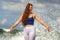 Young happy and attractive red hair woman playing excited spreading arms feeling free and relaxed getting wet by sea waves