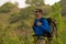 Young happy and attractive sporty hiker man with trekking backpack hiking at mountain feeling free enjoying travel getaway