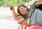 Young happy attractive woman smiling proud sitting at driver seat holding and showing car key in new automobile buy and rent conce