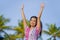 Young happy beautiful Asian Chinese tourist woman smiling relaxed wearing sweet dress walking rising arms free at tropical resort