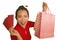 Young happy and beautiful Asian Chinese woman in red dress smiling cheerful holding shopping bags as excited spending money after