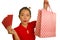 Young happy and beautiful Asian Chinese woman in red dress smiling cheerful holding shopping bags as excited spending money after