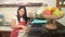 Young happy and beautiful Asian Korean home cook woman in red apron reading healthy recipe in mobile phone