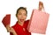 Young happy and beautiful Asian Korean woman in red dress smiling cheerful holding shopping bags as excited spending money after