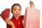 Young happy and beautiful Asian Korean woman in red dress smiling cheerful holding shopping bags as excited spending money after