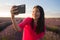 Young happy and beautiful Asian Korean woman in Summer dress taking sunset selfie with mobile phone at purple lavender flowers