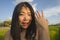 Young happy and beautiful Asian woman outdoors showing proud her engagement ring. cheerful Chinese girl  excited as fiance smiling