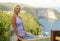 Young happy and beautiful blond woman relaxed at tropical beach cliff viewpoint enjoying Summer holidays getaway carefree at