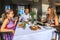 Young happy beautiful Caucasian family of father, mother and daughter have dinner by served restaurant table together