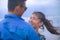 Young happy and beautiful Chinese Asian couple with woman hug her boyfriend romantic and cuddle on the beach