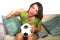 Young happy and beautiful football fan woman watching television game sitting on sofa couch holding soccer ball excited celebratin