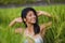 Young happy and beautiful hispanic woman smiling playful having fun posing sexy isolated on green rice field in Asia tourist trip