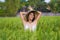 Young happy and beautiful latin woman playing with traditional Asian farmer hat smiling having fun posing sexy isolated on green