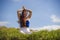 Young happy and beautiful red hair woman sitting on green field relaxed on grass practicing yoga exercise outdoors smiling in