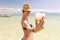 Young happy bikini woman holding salt chunk, Dead sea, Israel.