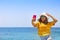 Young happy blond woman taking selfie portrait with mobile phone at beautiful tropical paradise view of ocean enjoying summer