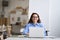 Young happy business woman company employee sitting at desk working on laptop.