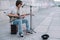 Young happy busker playing guitar and singing