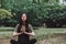 Young happy caucasian woman meditating alone in nature