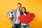 Young happy cheerful couple supporter, woman man, football fans cheer up support team, holding red heart love, soccer