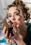 Young happy cheerful curly woman with glass of red wine and chocolate. Lady resting on the bed