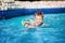 Young happy child boy swimming in pool with ring. into resort