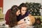 Young happy couple cuddling adorable akita inu dog with on the floor for Christmas holidays at home