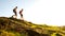 Young Happy Couple Hiking with Backpacks on the Beautiful Rocky Trail at Sunny Evening. Family Travel and Adventure.