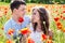 Young happy couple on a meadow full of poppies