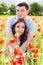 Young happy couple on a meadow full of poppies