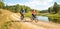 Young Happy Couple Riding Bicycles by the River