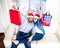 Young happy couple in Santa hat on Christmas holding shopping bags with presents