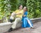 Young happy couple sits in the arbour twined greens