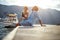 A young happy couple is sitting on the dock on the seaside and chatting with a drink. Love, relationship, holiday, sea