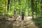 Young happy couple and their dog at hiking through the woods enjoying the sight. Two nature lovers in the mountain forest enjoy