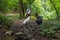 Young happy couple and their dog at hiking through the woods enjoying the sight. Two nature lovers in the mountain forest enjoy