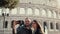 Young happy couple traveling in Rome, Italy. Man and woman taking the selfie photo on smartphone near the Colosseum.