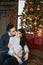 The young happy couple, in warm sweaters. Young handsome man kissing a beautiful girlfriend near the fireplace and