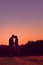 Young happy engaged couple silhouetted at sunset