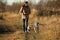 Young happy european smiling and laughing walking in a field with two dogs