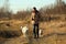 Young happy european smiling and laughing walking in a field with two dogs