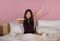 Young happy and excited Asian Korean woman in bed holding pregnancy test checking surprised positive pregnant result smiling ecsta