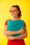 Young happy excited geek woman in red t shirt over vibrant yellow background