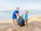 Young happy family activists collecting plastic waste on beach. Dad and son volunteers clean up garbage. Environmental