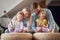 A young happy family is drumming on the furniture together. Family, home, playing, togetherness