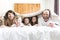 Young happy family of five on bedroom