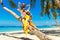 Young happy family-mom, dad, daughter and son having fun on a coconut tree on a sandy tropical beach. The concept of travel and